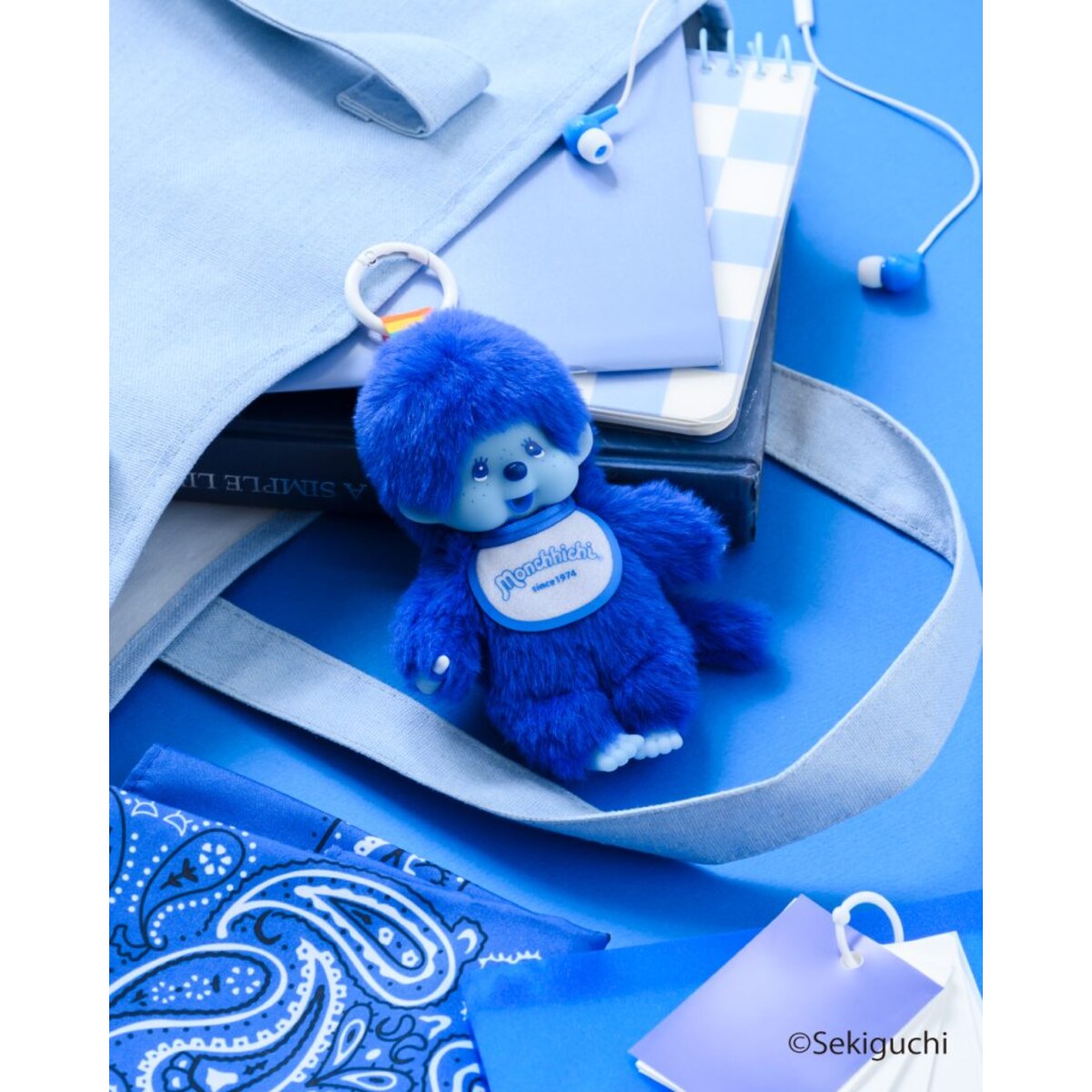 Blue macaron Monchhichi Colorful Fantasy plush keychain on blue desk accessories