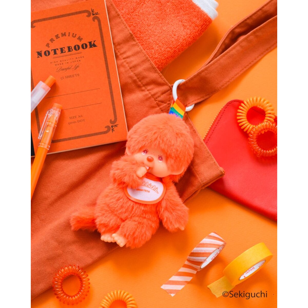 Orange macaron Monchhichi Colorful Fantasy plush keychain with orange stationery and notebooks