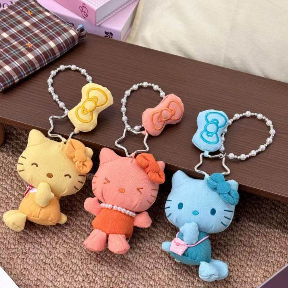 Sanrio Hello Kitty Denim Series blind box plush pendants in yellow, coral and blue with pearl bead chains