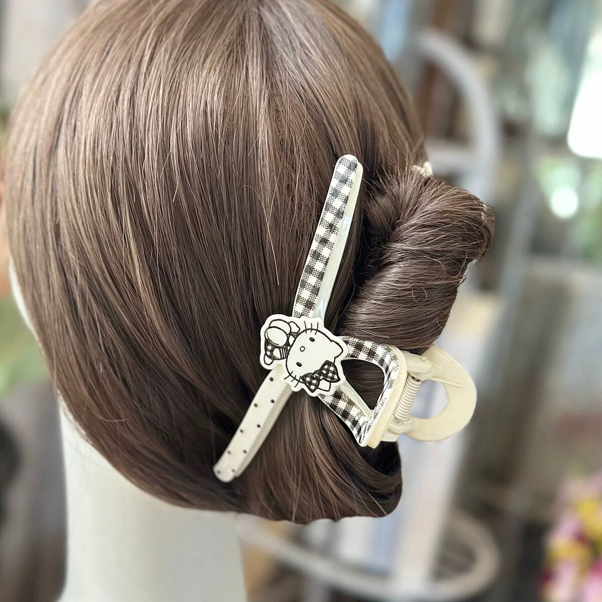 Hello Kitty gingham wishbone claw clip worn in brown hair bun