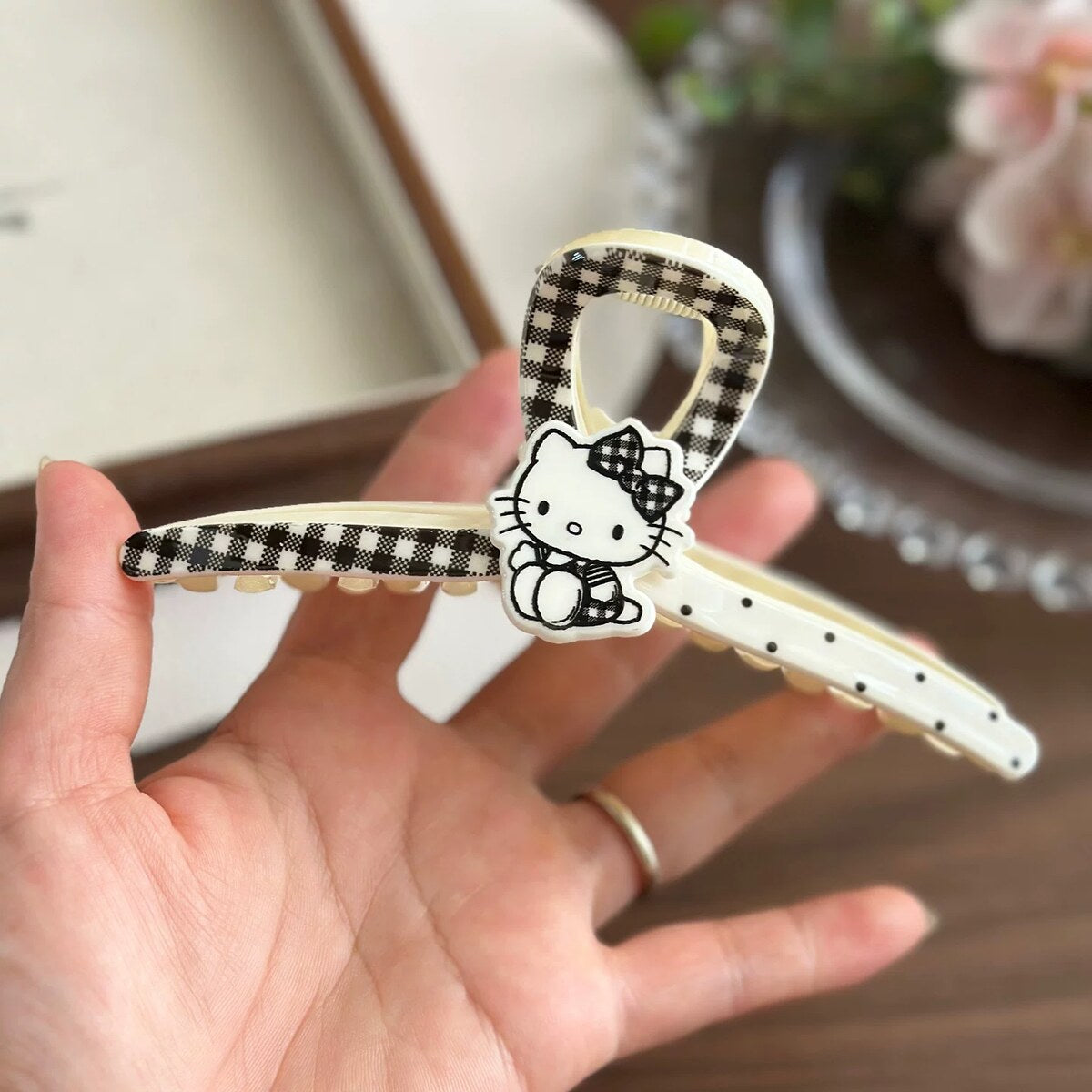 Hello Kitty ivory wishbone claw clip with gingham bow print held in hand