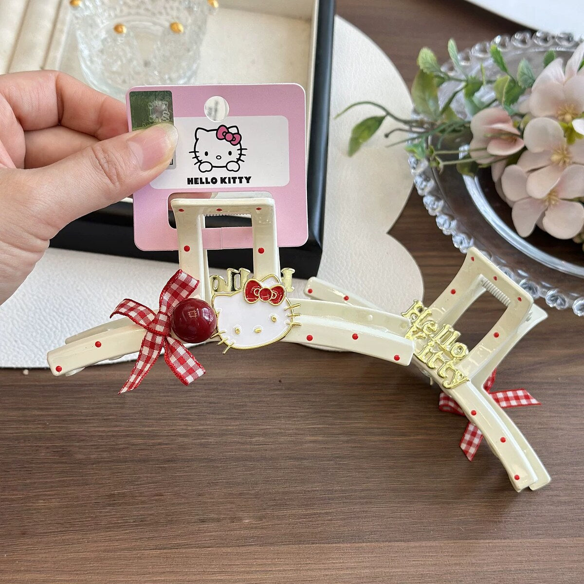 Hello Kitty red polka dot cream claw clip with gingham bow, cherry bead and gold Kitty charm on official brand card