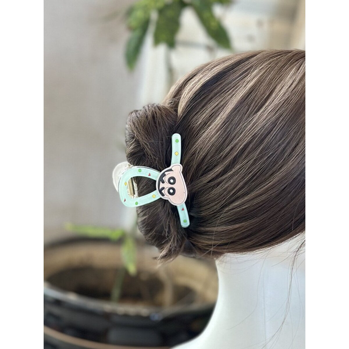 Crayon Shin-chan face claw clip worn in an updo - back view