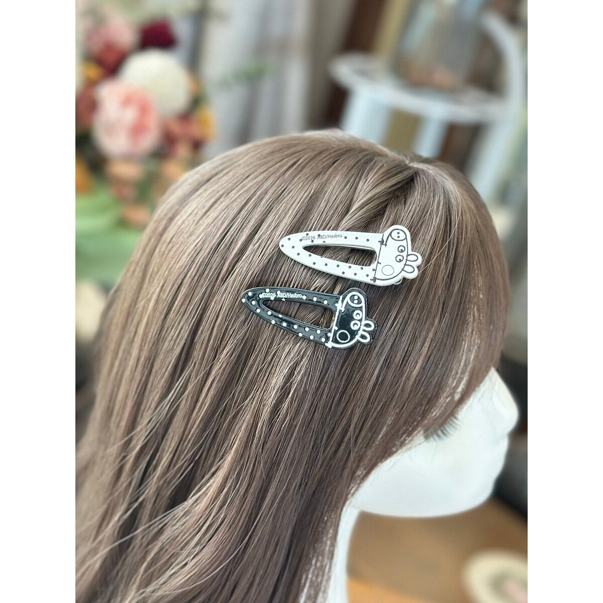 Peppa Pig snap clips worn together on long side hair