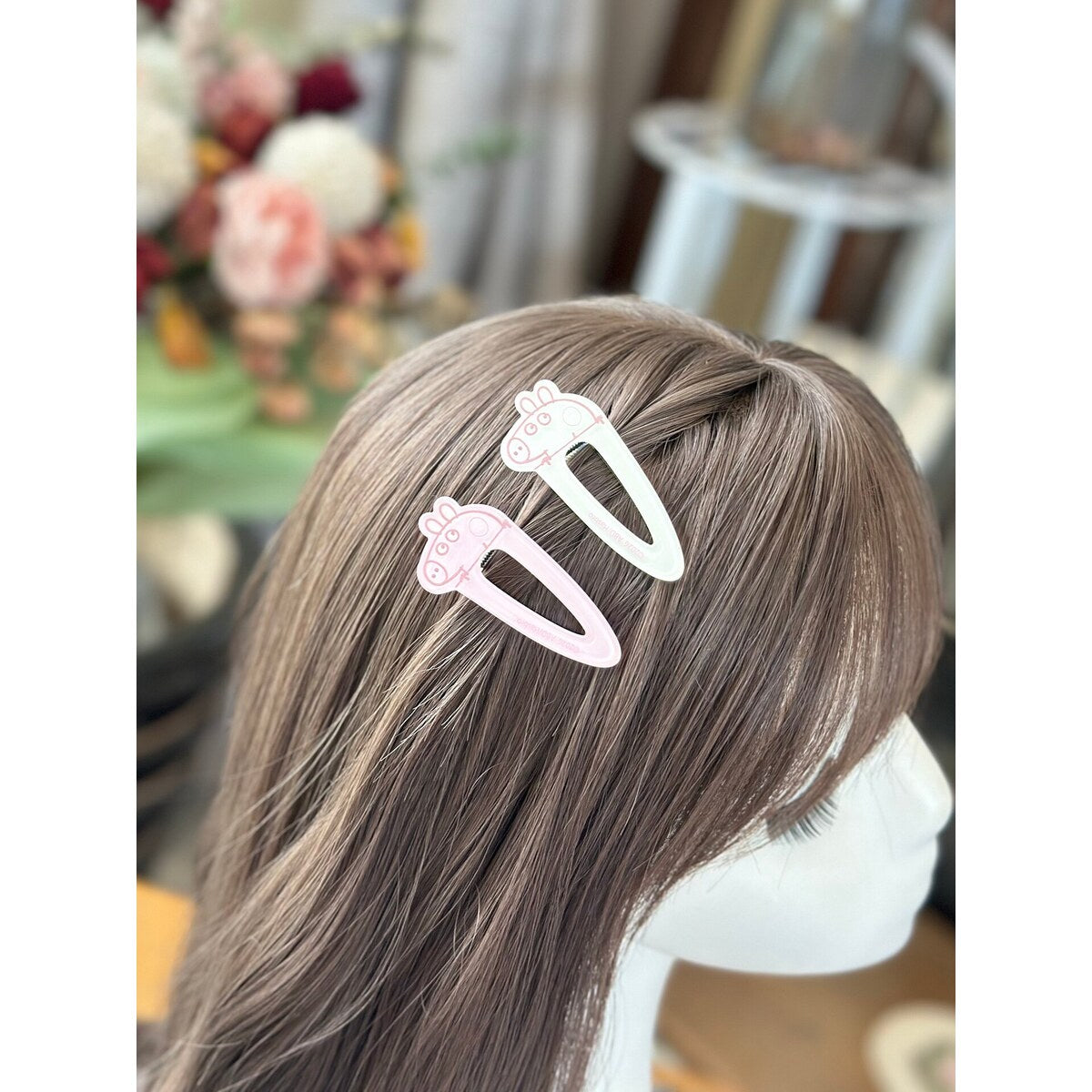Pink and white Peppa Pig water drop snap clips worn on side hair