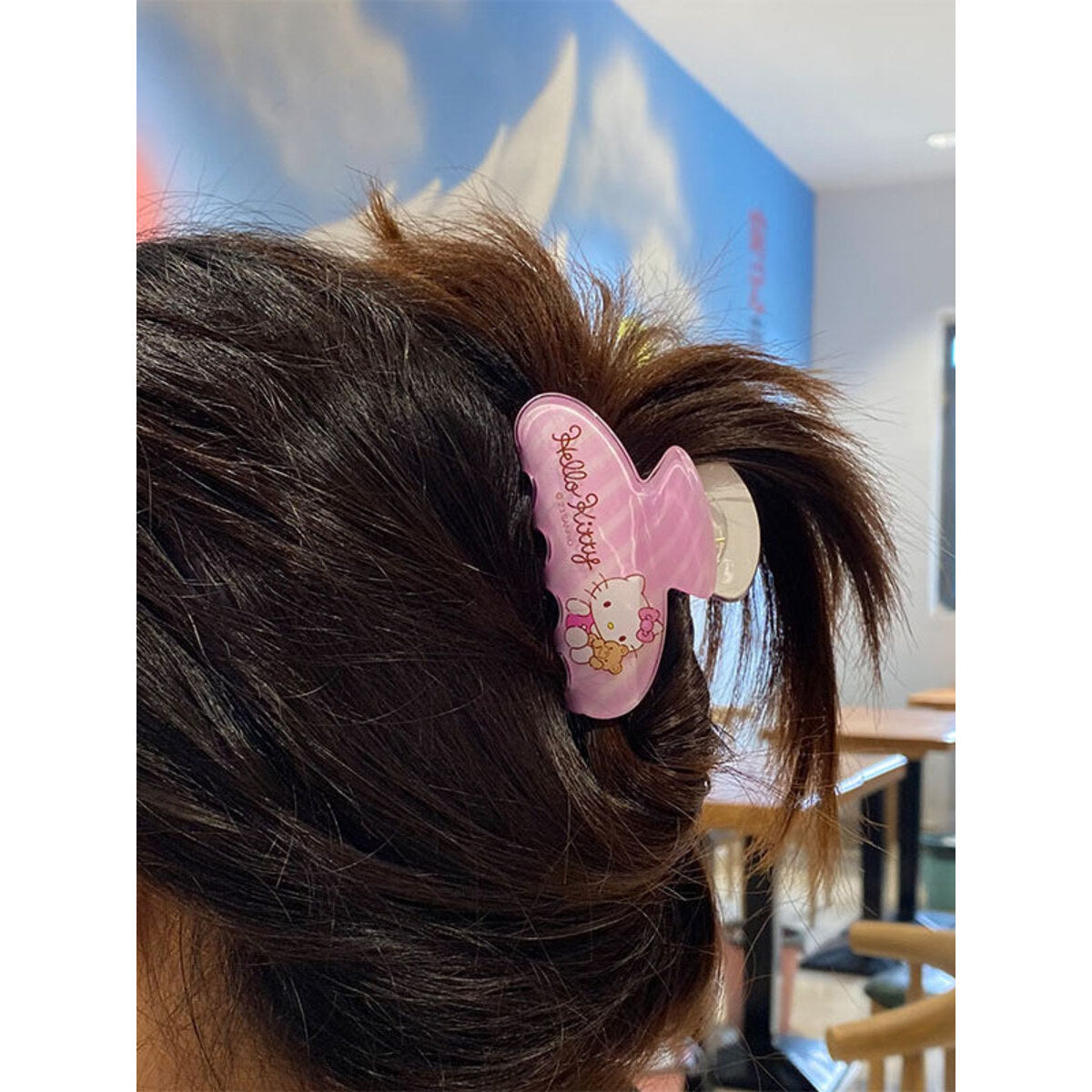 Hello Kitty pink iridescent claw clip worn in a half-up hairstyle