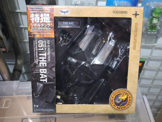 Back of the retail packaging for the Kaiyodo Sci-Fi Revoltech No. 051 The Bat vehicle action figure, showcasing product features including engine articulation, opening cockpit hatch with a boarding miniature Batman figure, movable tail wings, and display stand setup.