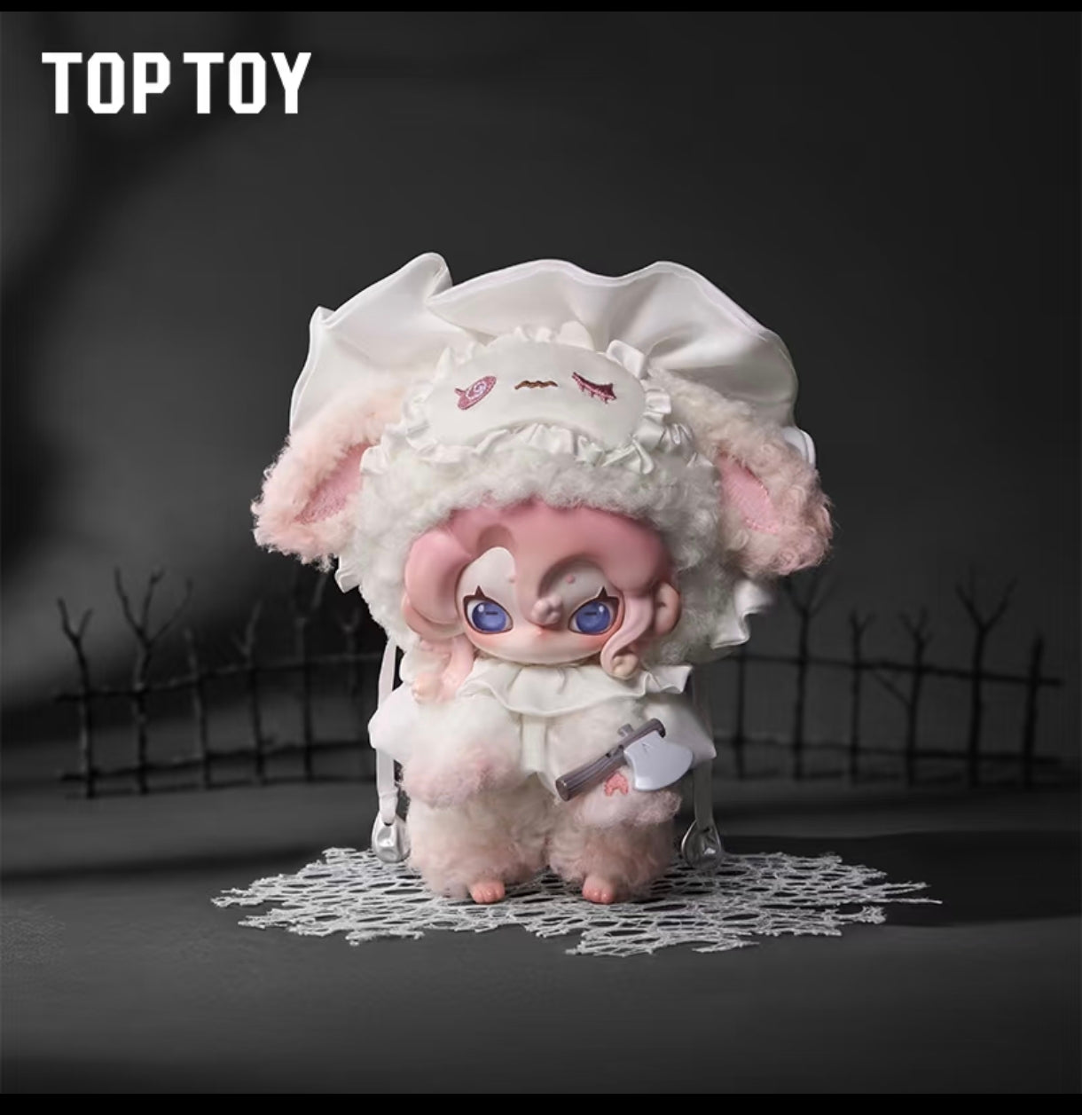 Close-up of a Moonin The Shrouded Night plush figure featuring pink hair, blue eyes, and a white ruffled sleep mask holding a miniature plastic axe weapon.