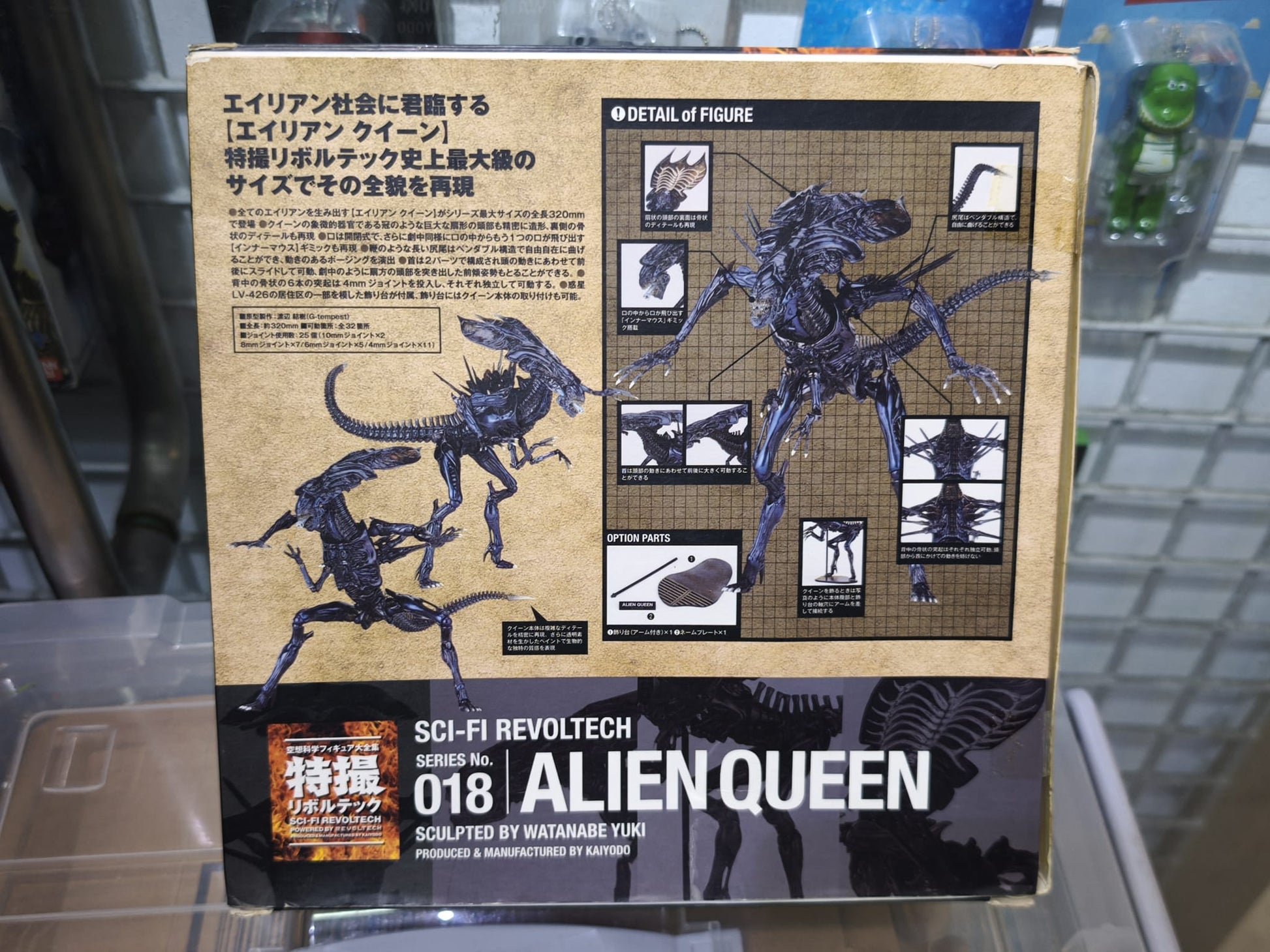 Front display window packaging of the Kaiyodo Sci-Fi Revoltech Series No. 018 Alien Queen collectible figure from the movie Aliens, showing the large Xenomorph Queen figure inside alongside its specialized stand components and logo branding.
