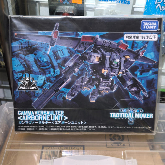 Front panel of the Takara Tomy Diaclone box featuring a dramatic illustration of the dark grey Gamma Versaulter Airborne Unit flying with its wings deployed against a high-tech blue grid background.