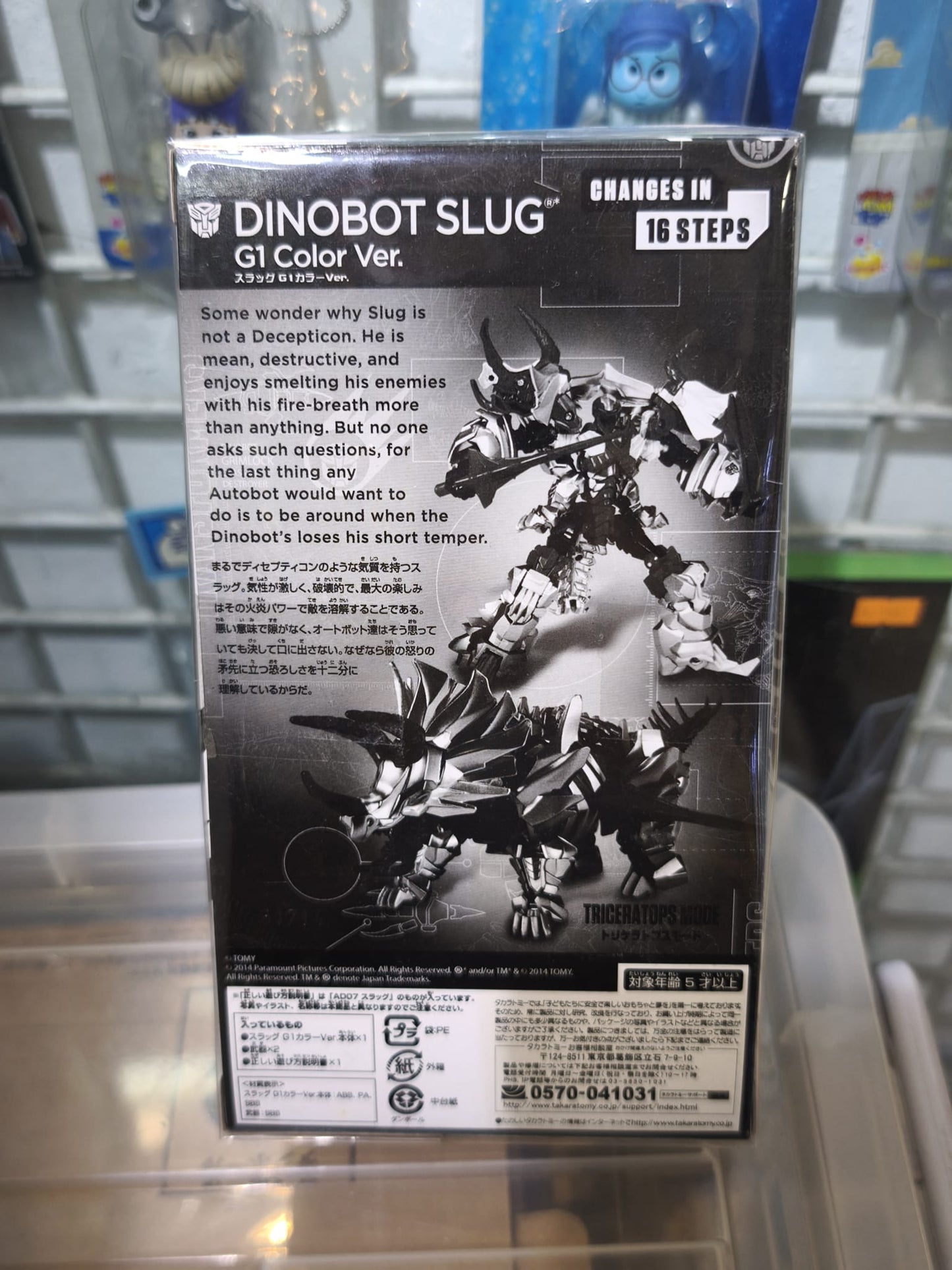 Front retail window box packaging for the Japanese exclusive Takara Tomy Transformers Movie Advanced Series Dinobot Slug (G1 Color Ver.), displaying the deluxe action figure inside alongside its dual weapons and authentic movie branding.