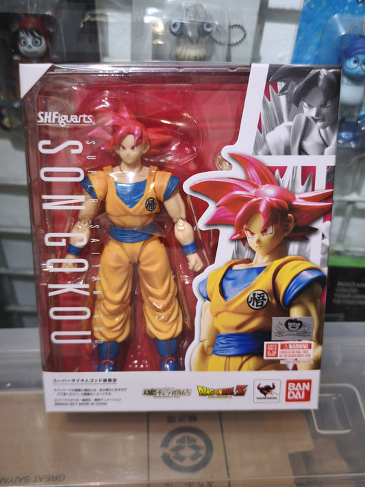 Front window box packaging of the Bandai S.H.Figuarts Super Saiyan God Son Goku action figure featuring a metallic Tamashii web shop quality emblem.