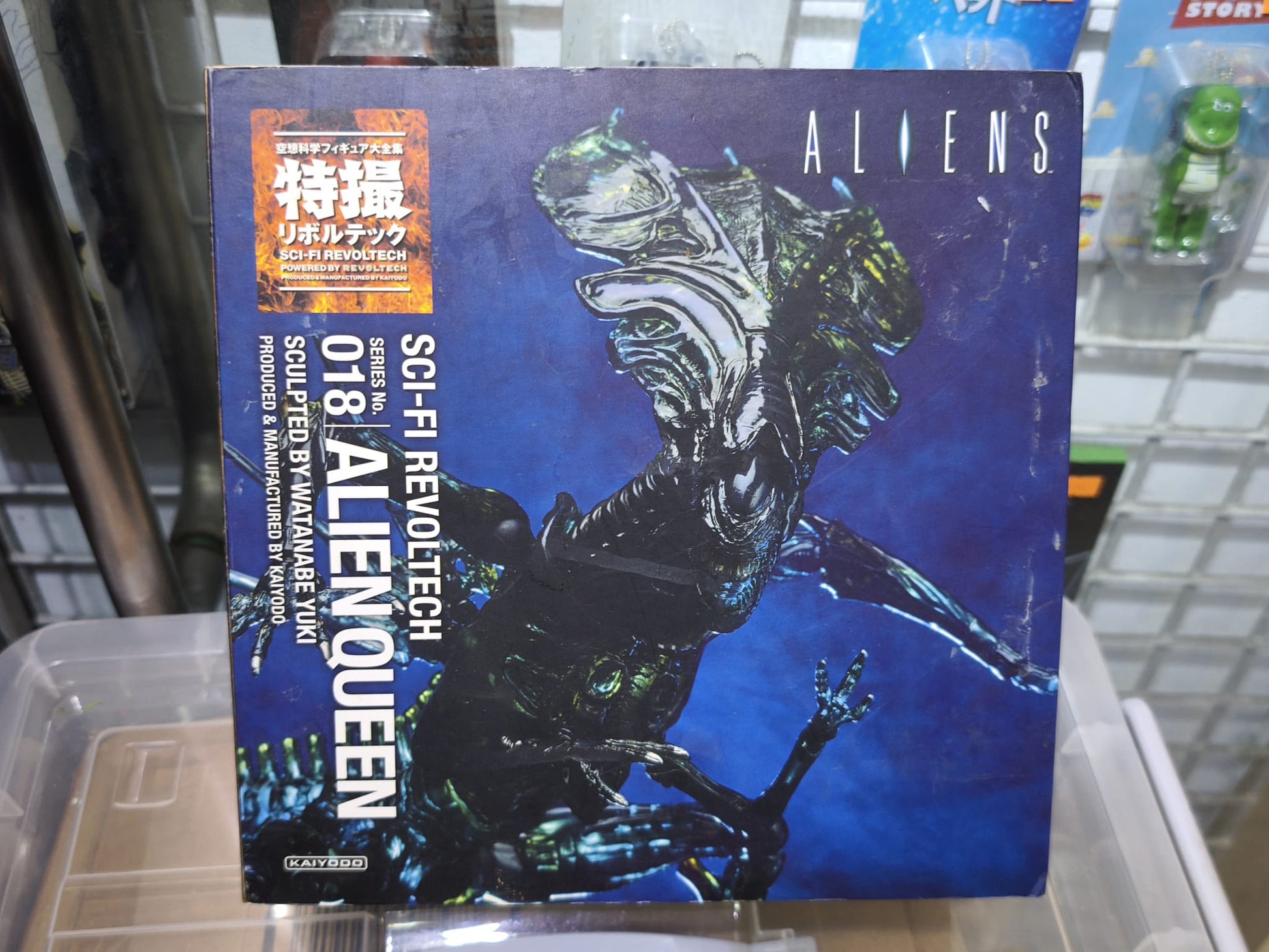 The reverse packaging of the Kaiyodo Sci-Fi Revoltech No. 018 Alien Queen action figure, illustrating product details including the extendable inner mouth mechanism, bendable wire tail, poseable back spines, and the LV-426 planet display base setup.