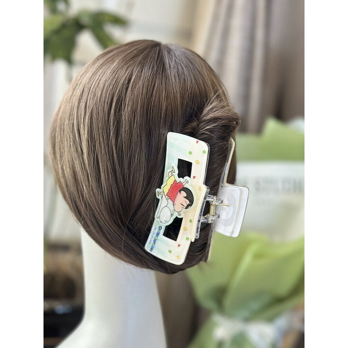 Crayon Shin-chan mint claw clip worn in a low bun - side profile