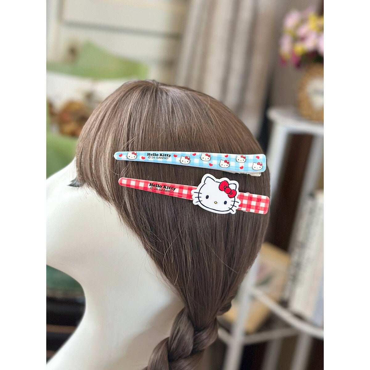 Hello Kitty extra large bar clips holding side hair - blue floral and red check pair worn