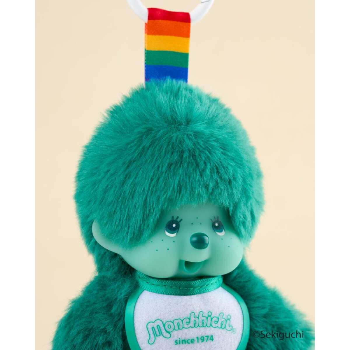 Close-up of the green macaron Monchhichi Colorful Fantasy plush keychain with its rainbow strap