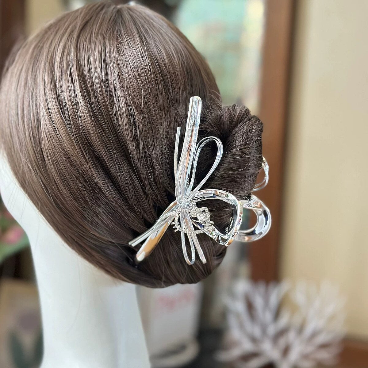 Silver bow claw clip styled in a low bun