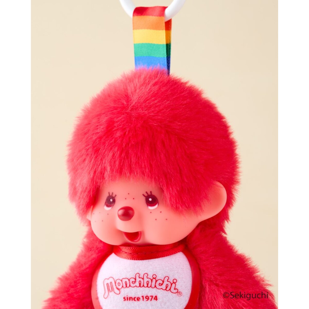 Close-up of the red macaron Monchhichi Colorful Fantasy plush keychain with its rainbow strap