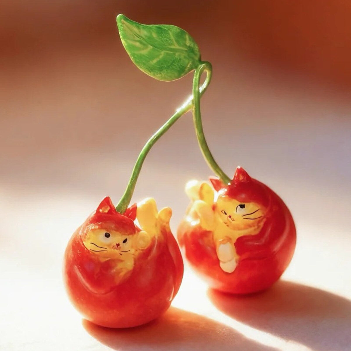Cherry Cat pair figure on a stem with a green leaf from the 52TOYS x COMUGI Fruit Cat Series