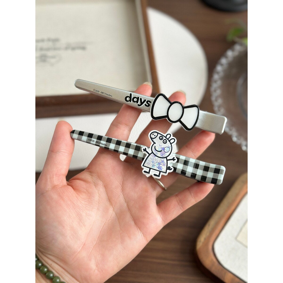 Peppa Pig days bow and gingham bar clips held in hand