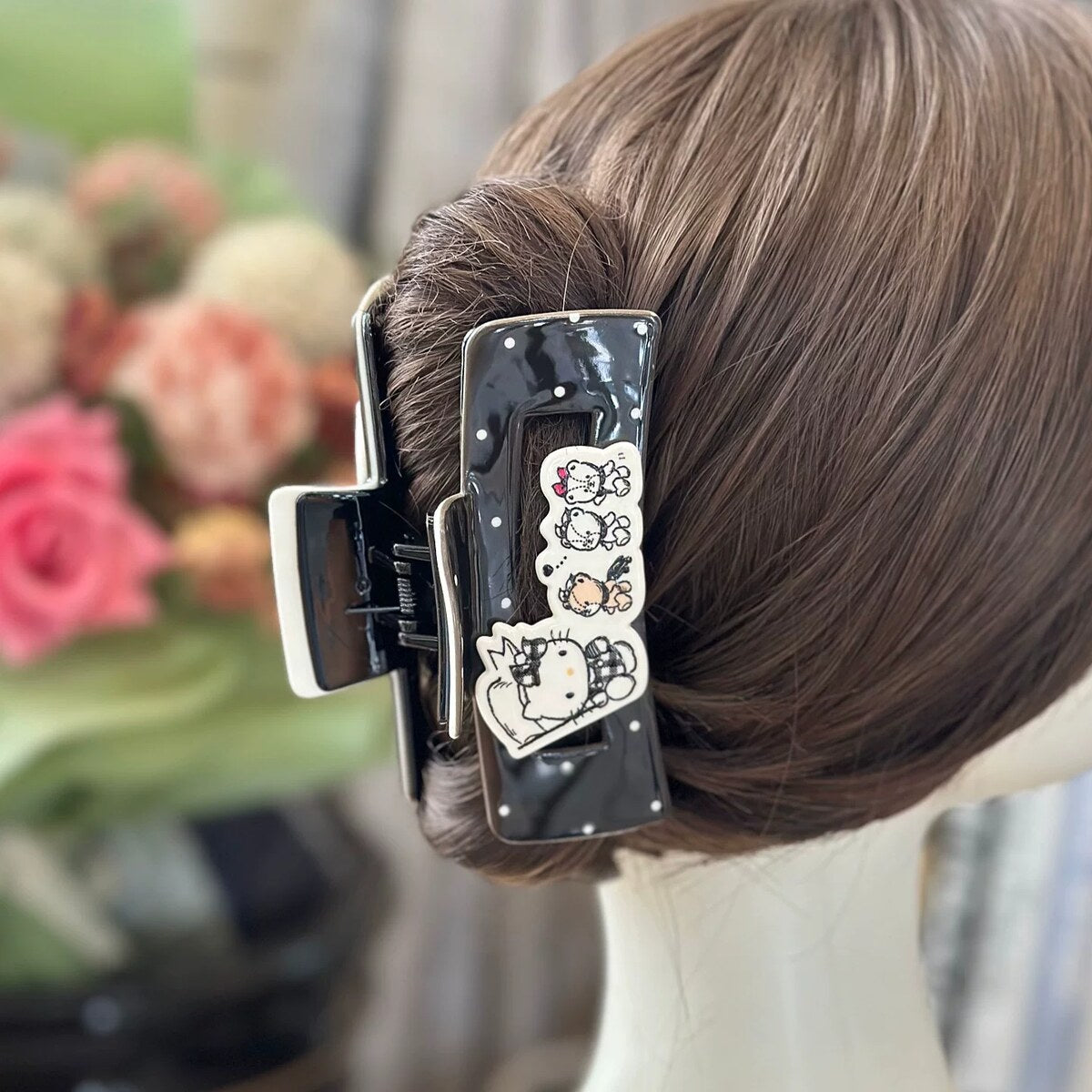 Hello Kitty black polka dot rectangular claw clip worn in updo hairstyle