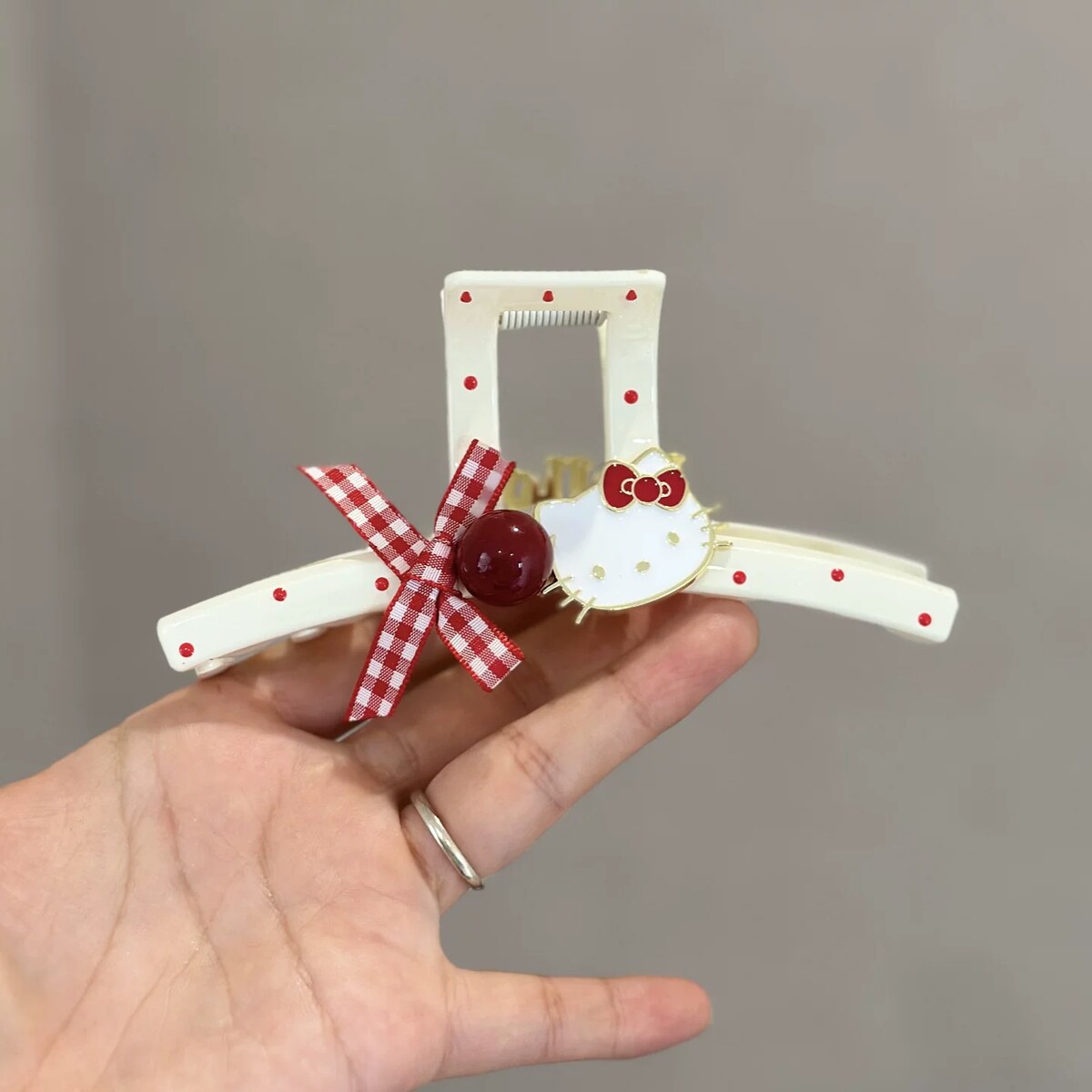 Hello Kitty wavy-edge double-sided claw clip with red polka dots and gingham bow detail
